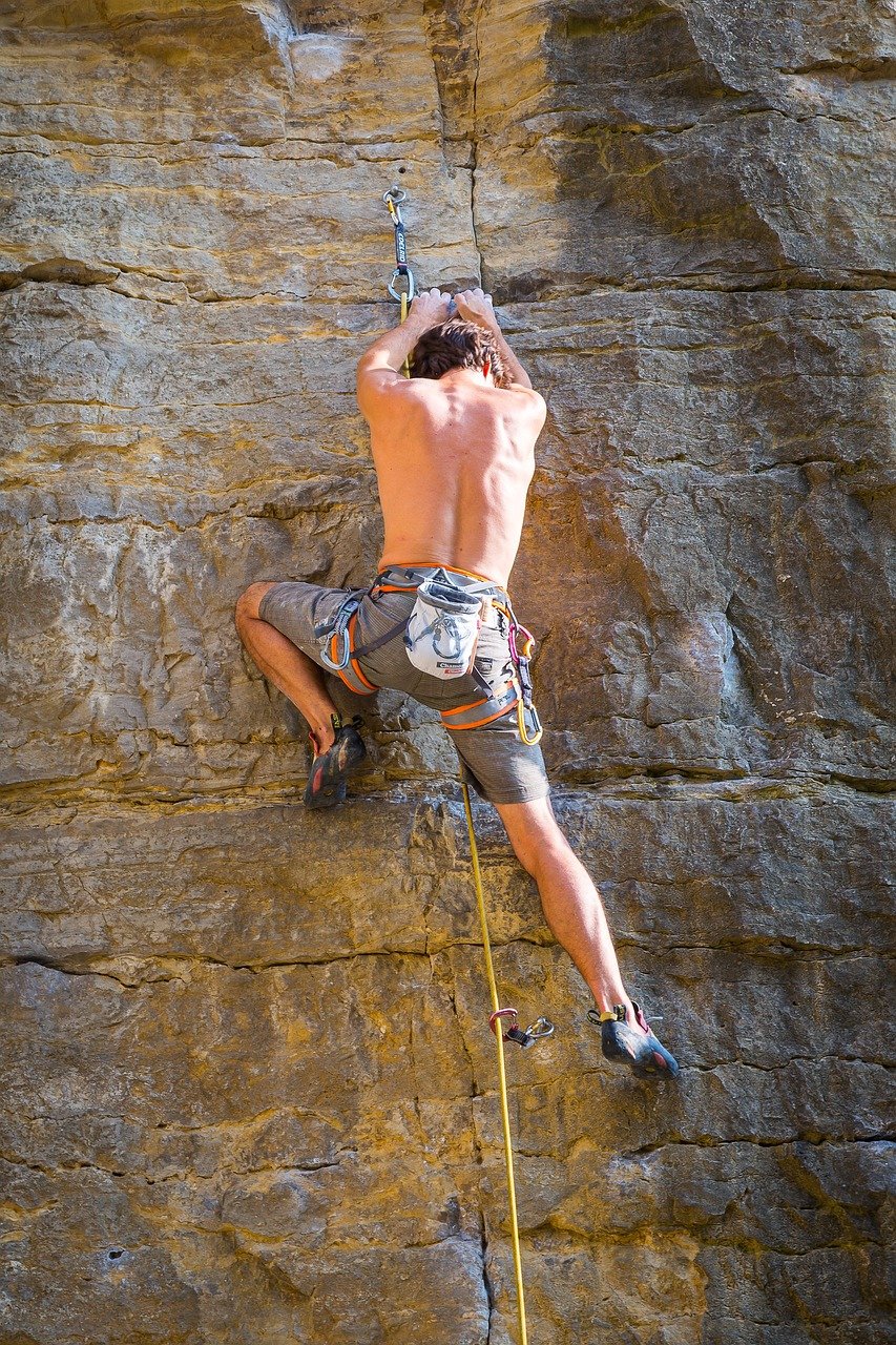 rock climber with gear ascending a mountain